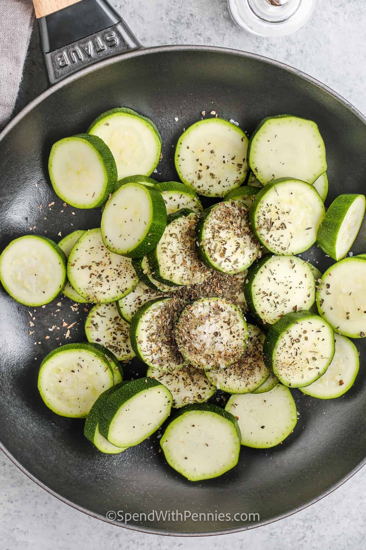 adding seasonings to zucchini to make Sauteed Zucchini