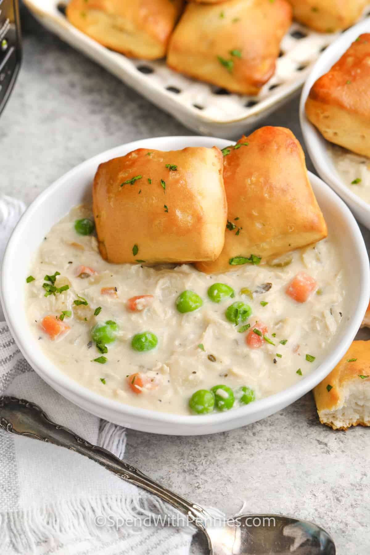 instant pot chicken pot pie soup in a bowl with buns