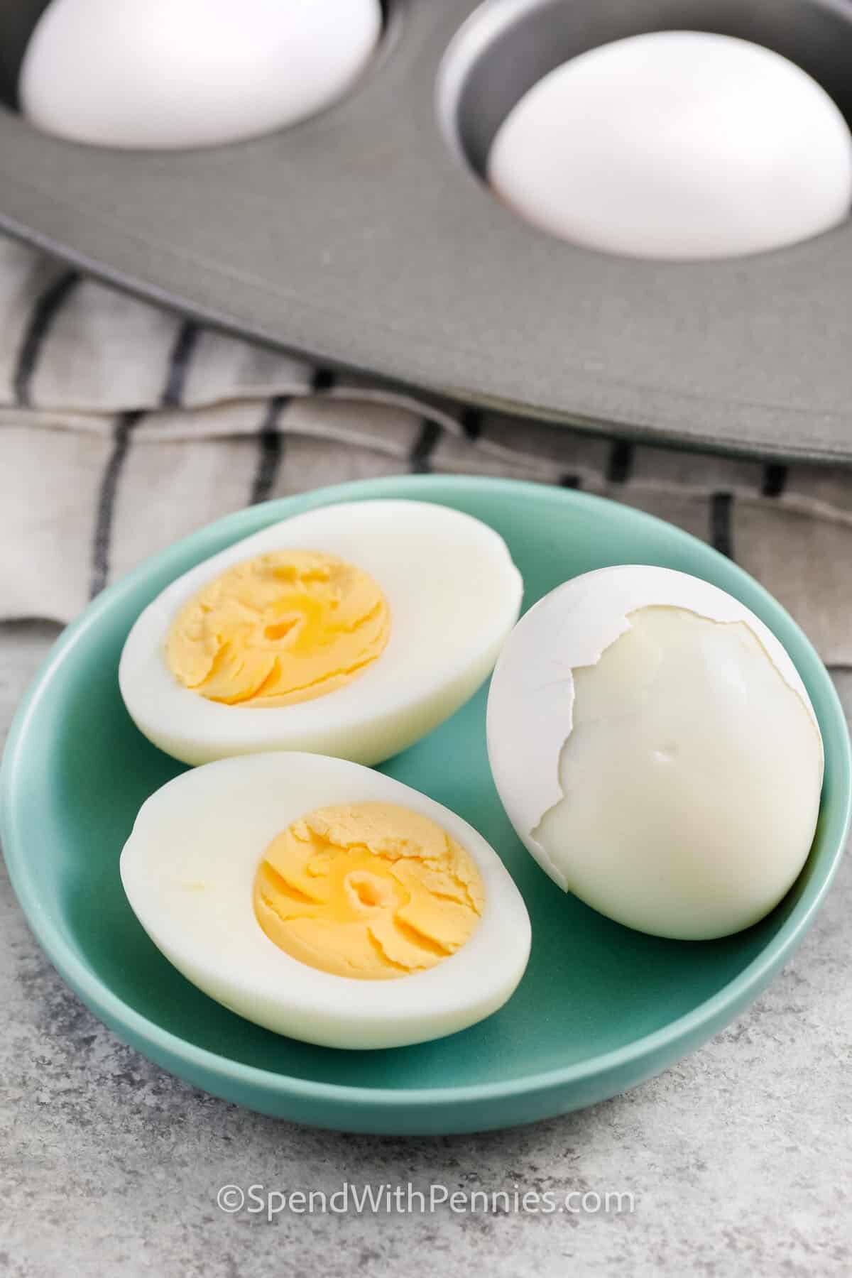 Hard Boiled Eggs in the Oven cut into half on a plate